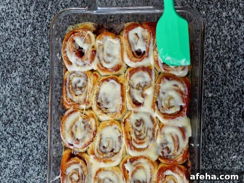 spreading warm rolls with a small amount of icing using silicone spatula.