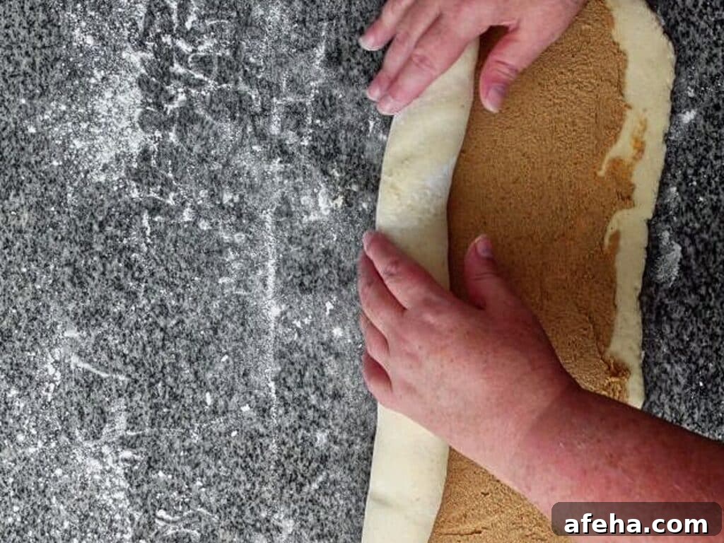rolling up sweet dough spread with orange filling.
