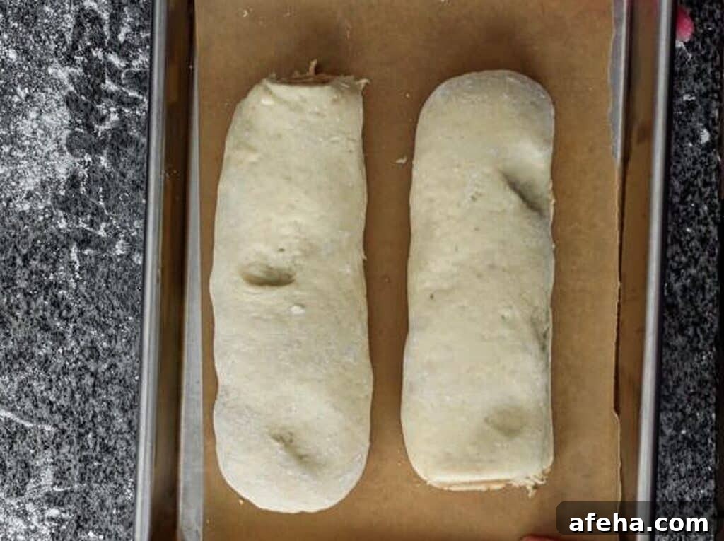 log of orange rolls cut in half and placed on parchment-lined baking sheet.