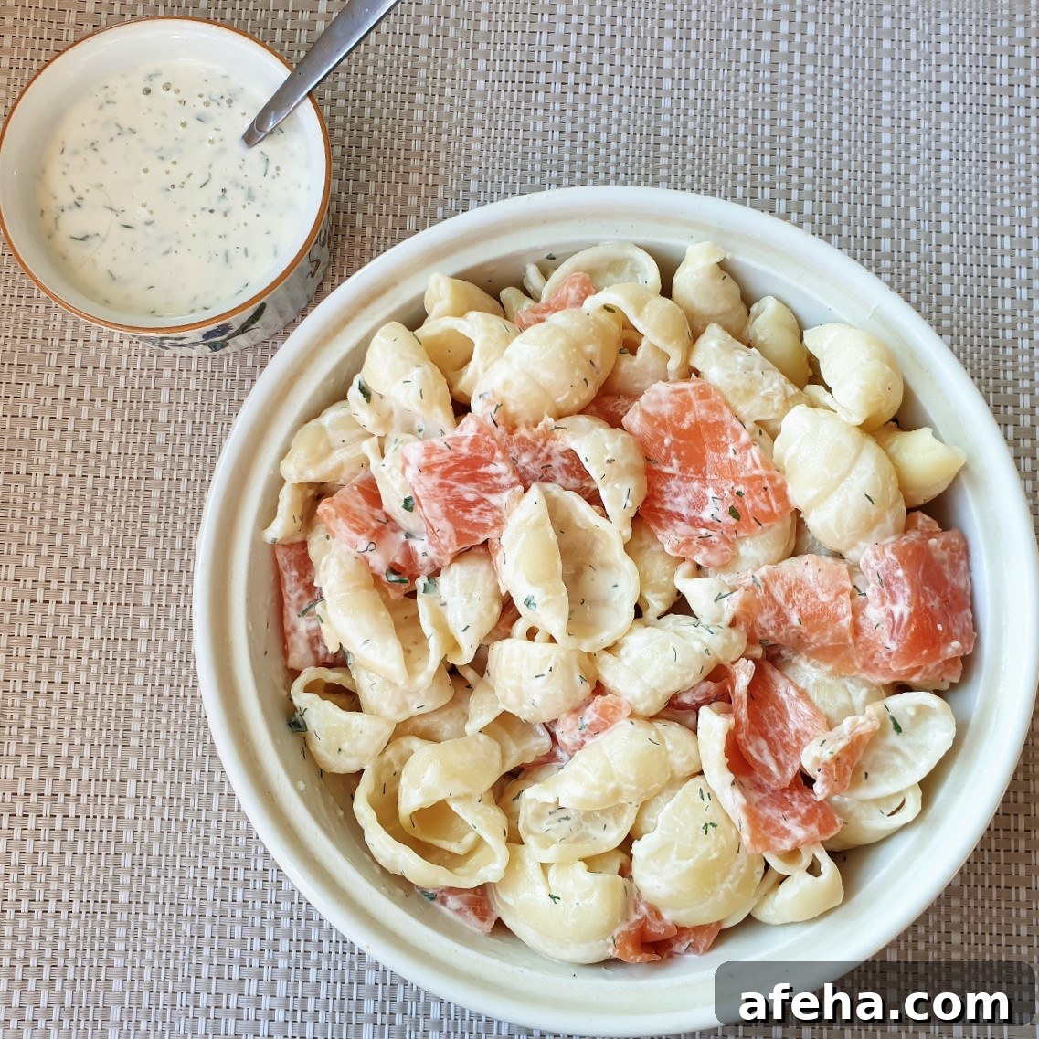 A bowl of smoked salmon pasta salad with a dish of homemade ranch dressing.