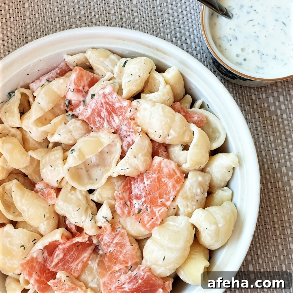 A bowl of smoked salmon pasta salad with a dish of homemade ranch dressing.