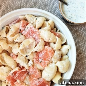 A bowl of smoked salmon pasta salad with a dish of homemade ranch dressing.