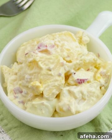 Closeup photo of a single serving bowl of potato salad.