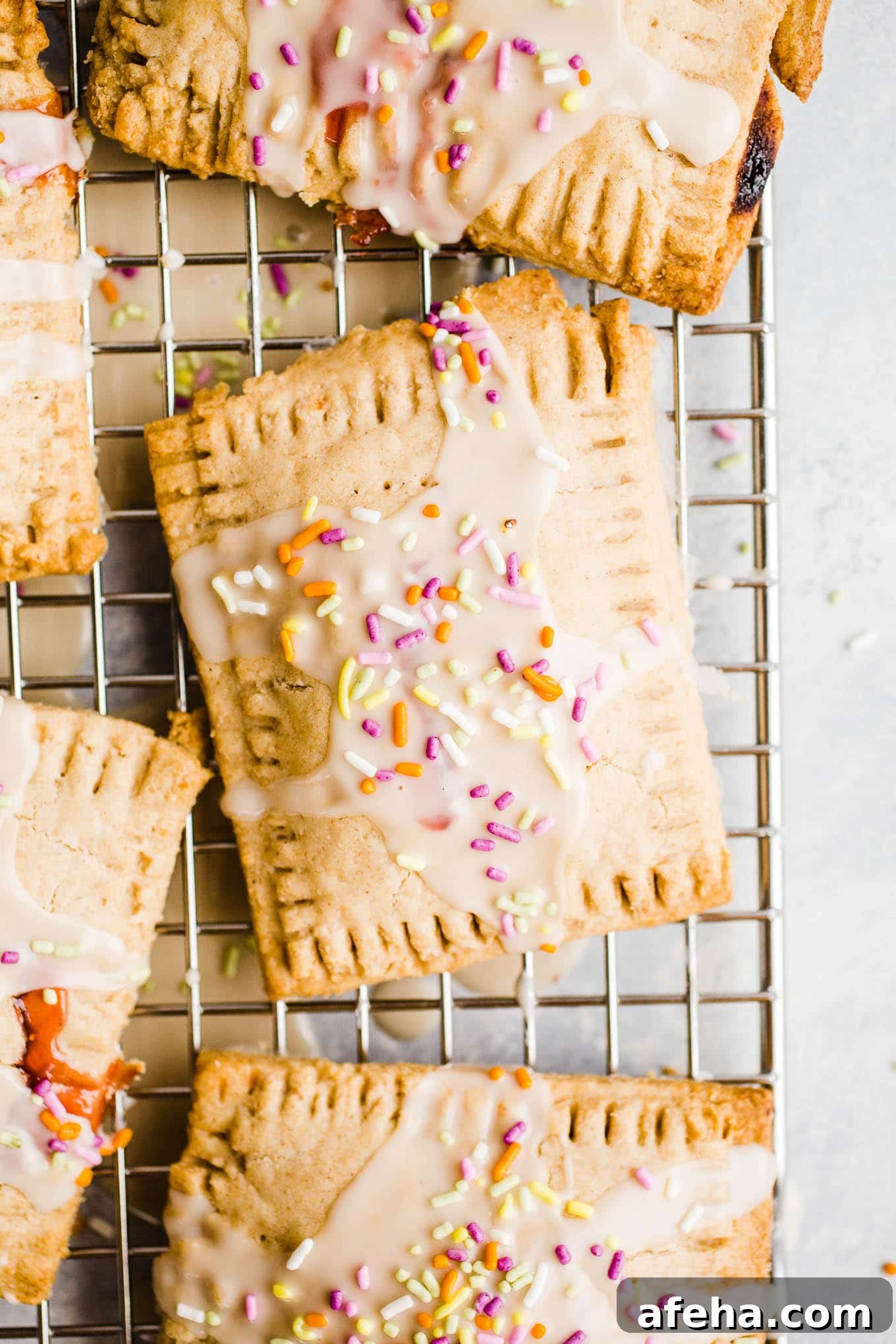 Glazed toaster pastries with sprinkles on a wire rack.