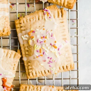 Glazed toaster pastries with sprinkles on a wire rack.