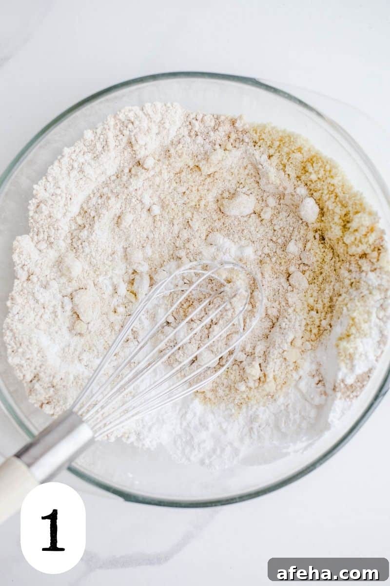 Gluten-free flours being mixed in a glass bowl. 