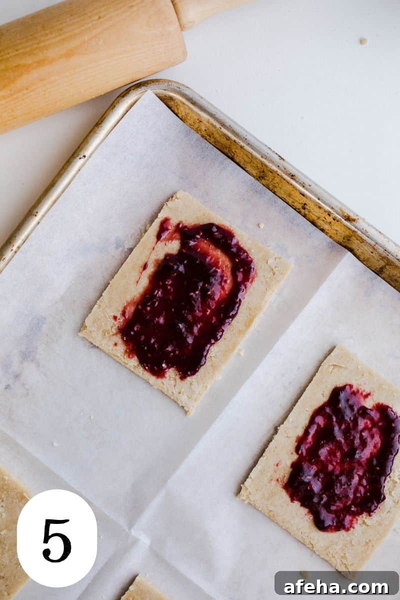 Jam spread on pastry dough squares.