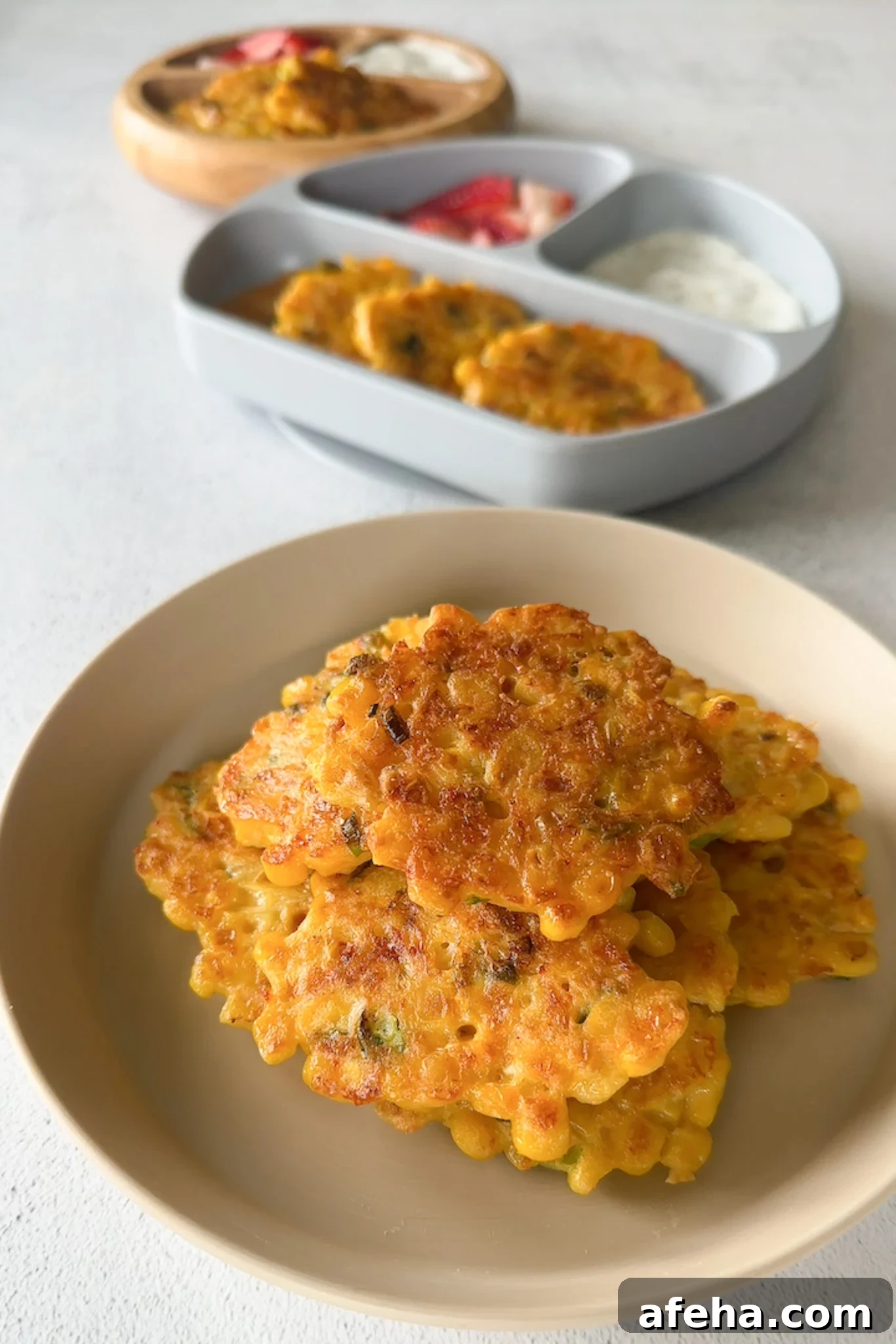 Sweet corn fritters served with strawberries and a dip.