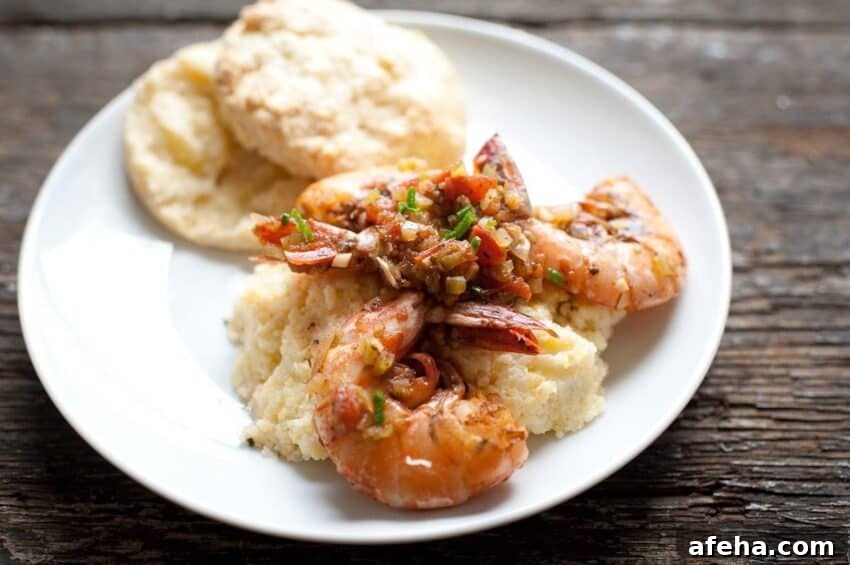shrimp and grits recipe on a plate with a biscuit