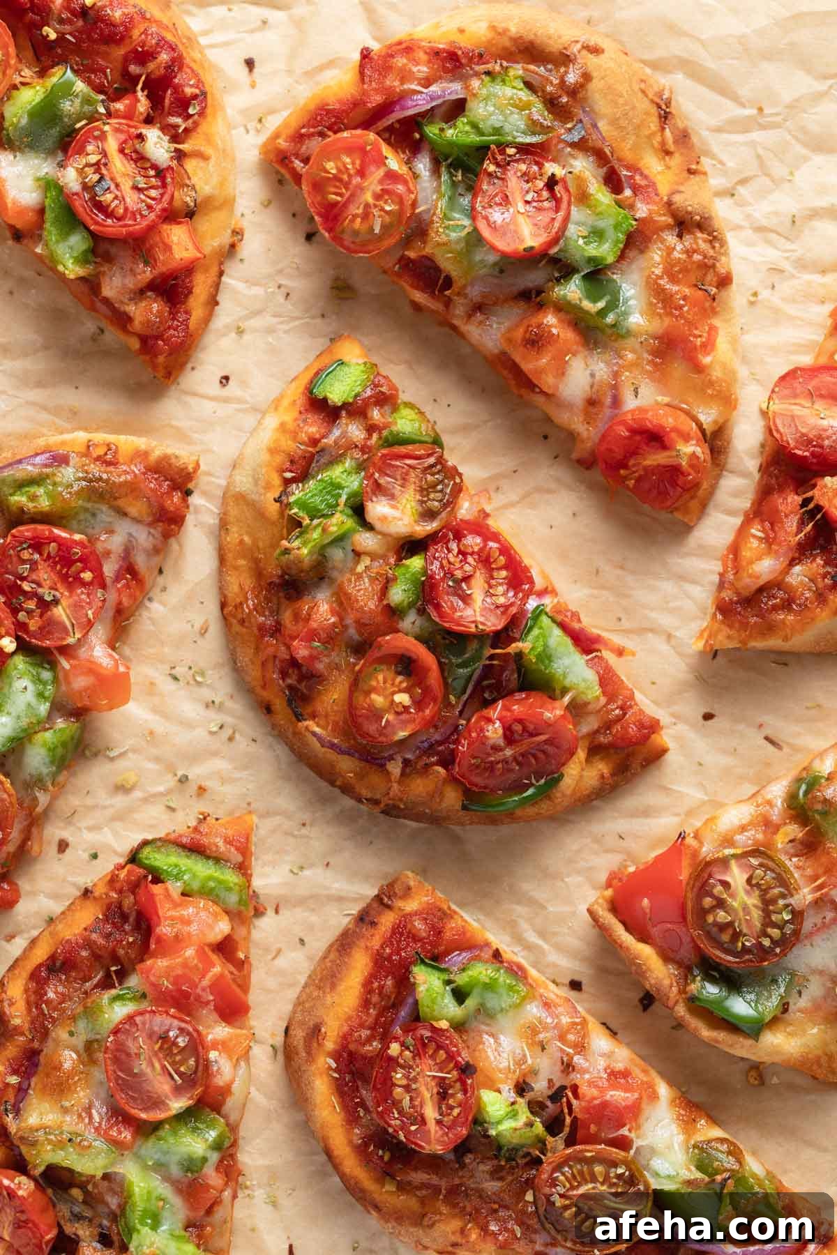 Mini Naan Bread Pizzas Made in the Air Fryer 2 Air fryer mini pizzas made with naan bread and arranged on a sheet of parchment paper.