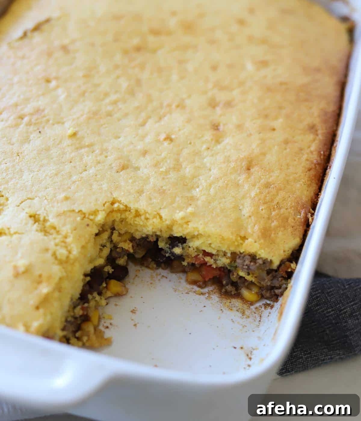 Cornbread casserole in casserole dish with one square missing.