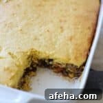 Cornbread casserole in casserole dish with one square missing.