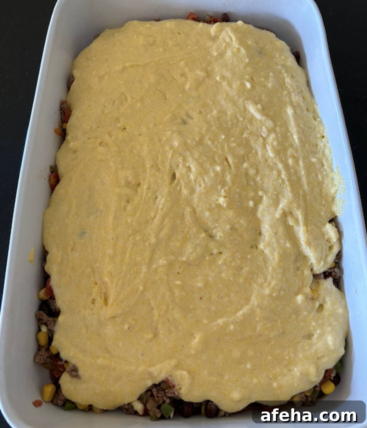 Cornbread covered over ground beef.
