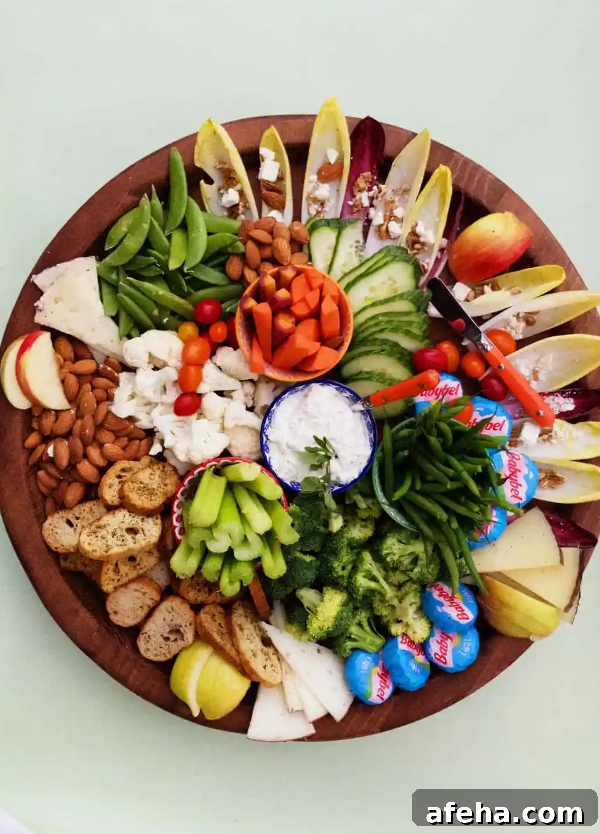 Celery, cucumbers, broccoli, nuts, and cheese are shows on Reluctant Entertainers cheese board.