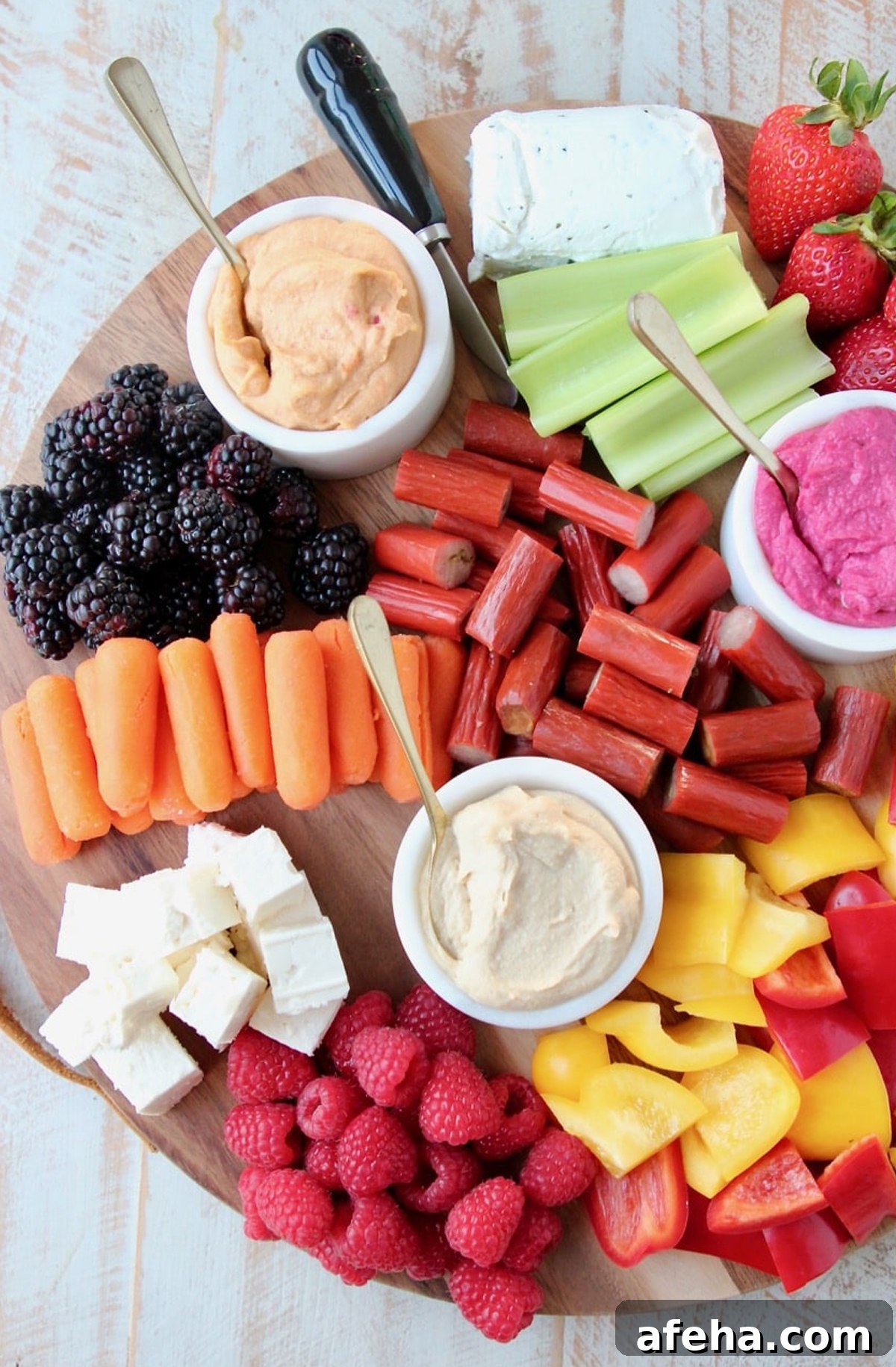 Strawberries, spreads, celery, berries, and carrots are showcased on Whitney Bonds board.