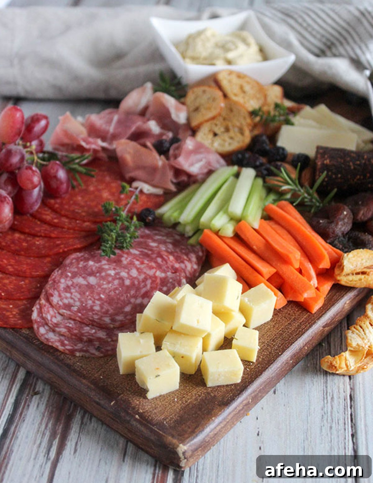 Simple and Savory displays, celery, carrots, meats, cheese, and grapes on their charcuterie board.
