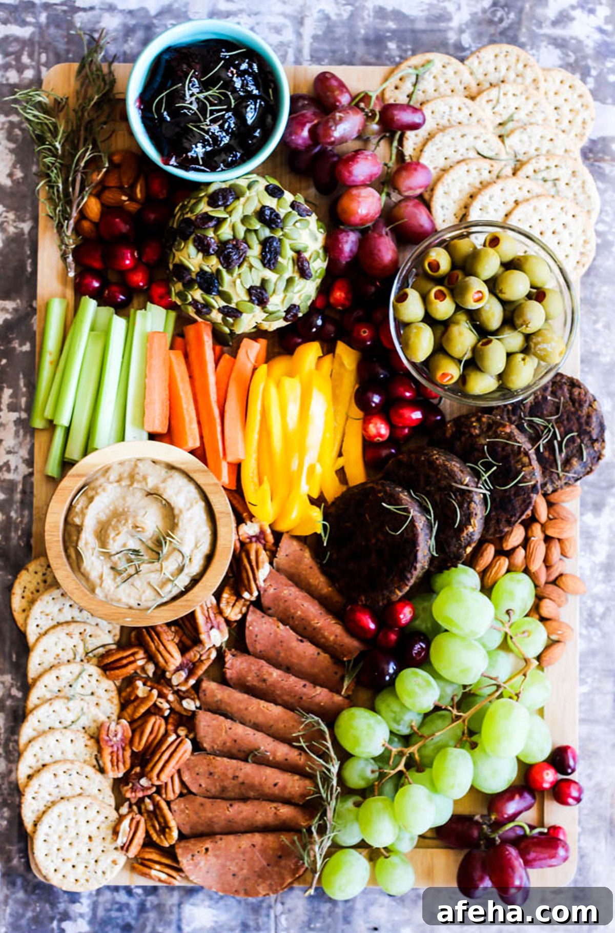 Jelly, grapes, nuts, crackers, celery, carrots, and olives are included on Emilie Eats charcuterie board.