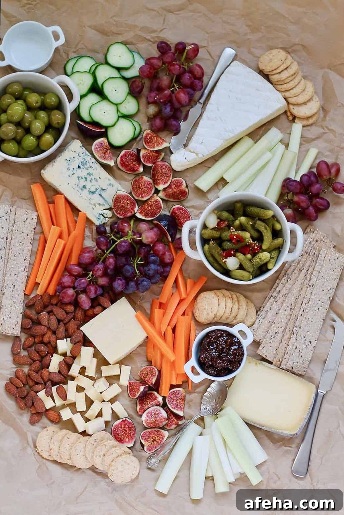 Hey Nutrition Lady presents a board full of cheese, cucumbers, pickles, carrots, and grapes.