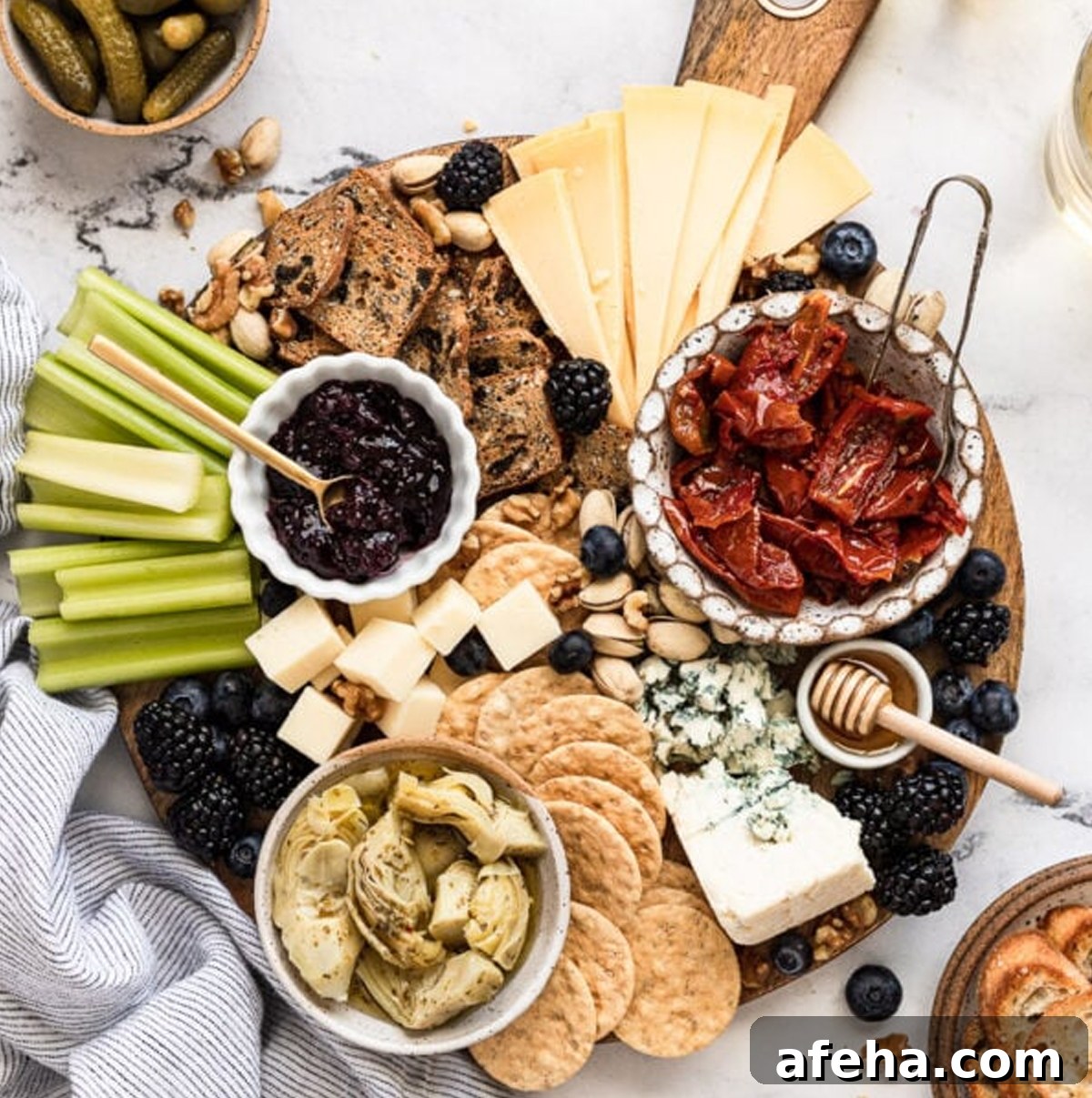 Fork in the Kitchens board shows dill pickles, cheeses, roasted tomatoes, and berries.
