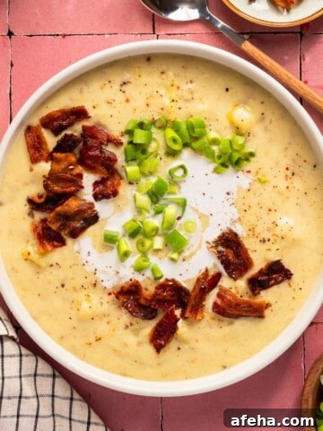 A bowl of creamy dairy free potato soup topped with bacon bits and chopped green onion.