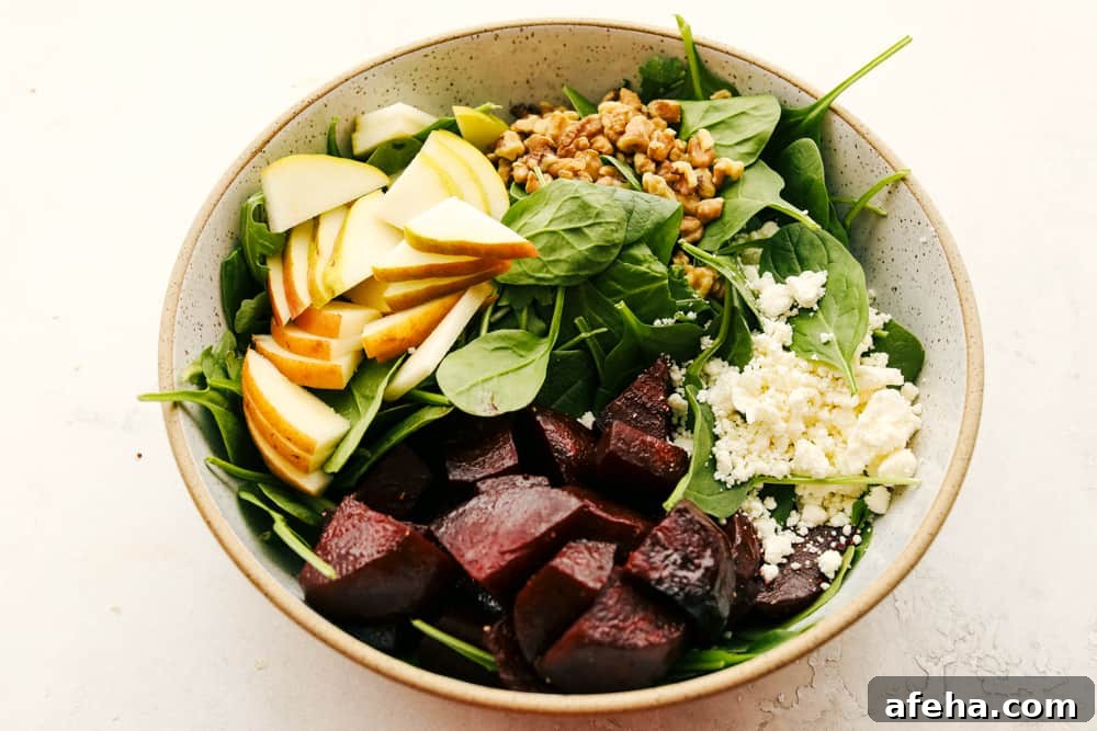 Pears, beets, spinach, feta and nuts in a bowl.