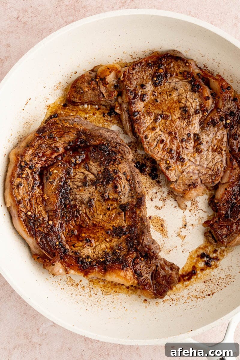 Searing the ribeye steaks in the pan before making the cream sauce