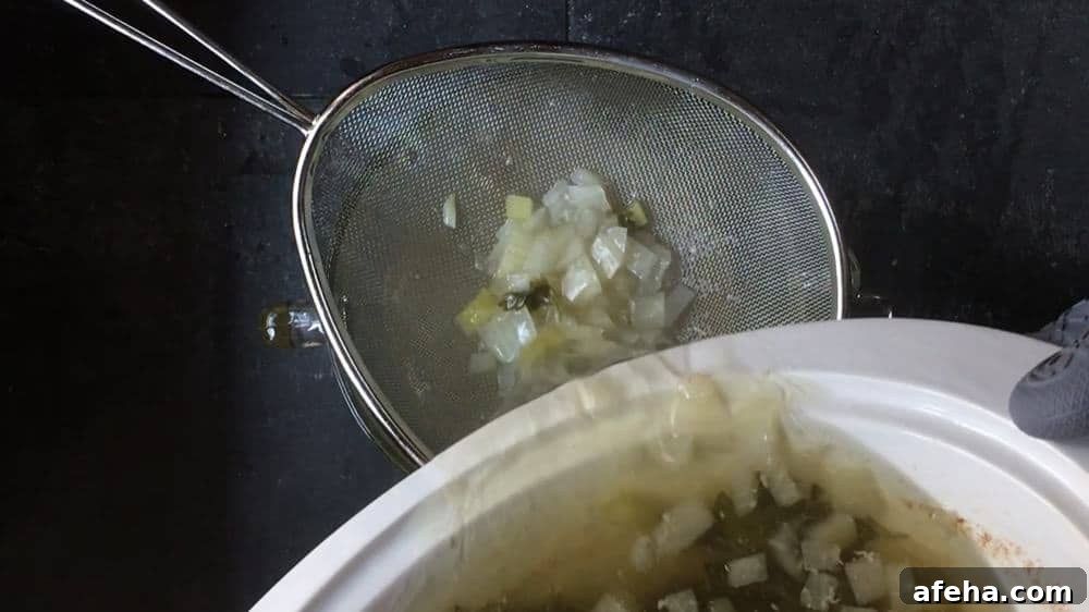 straining homemade chicken broth