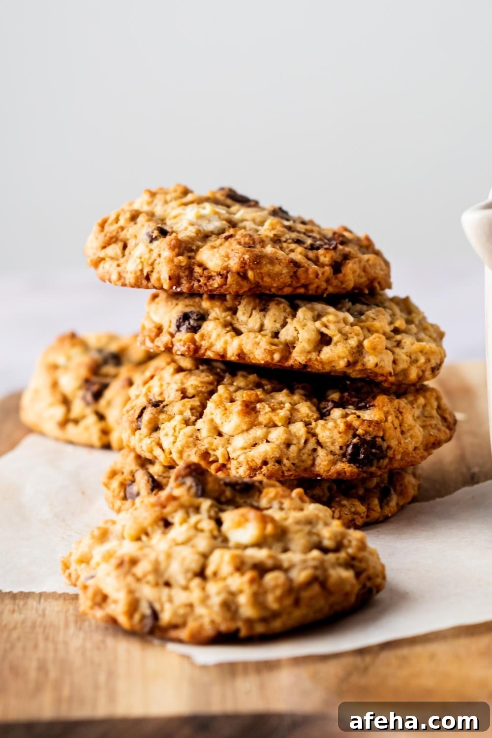 A tall stack of mom's recipe crumble cookies on parchment paper on a cutting board.