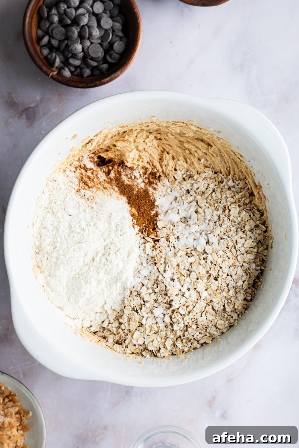A bowl with the wet ingredients for the mom's recipe cookies, all of the dry ingredients have just been added.