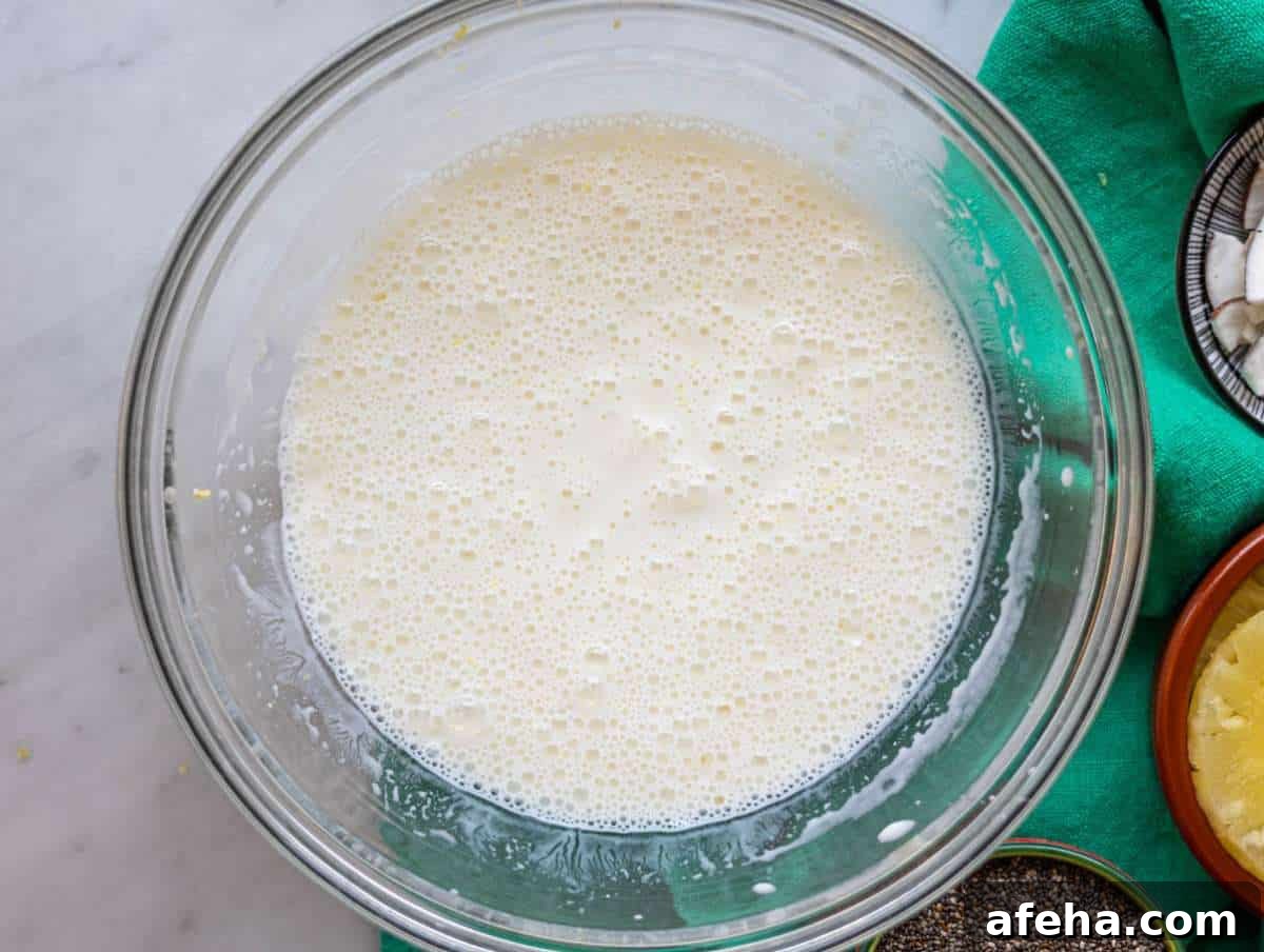 Step 1 Whisking Greek yogurt, milk, and pineapple juice in mixing bowl.