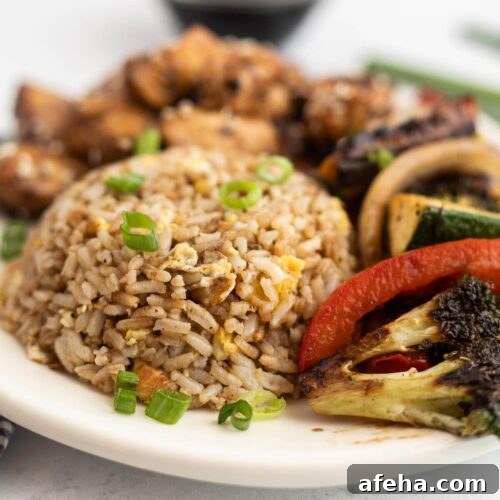 Brown rice, roasted broccoli and tomatoes on a plate.