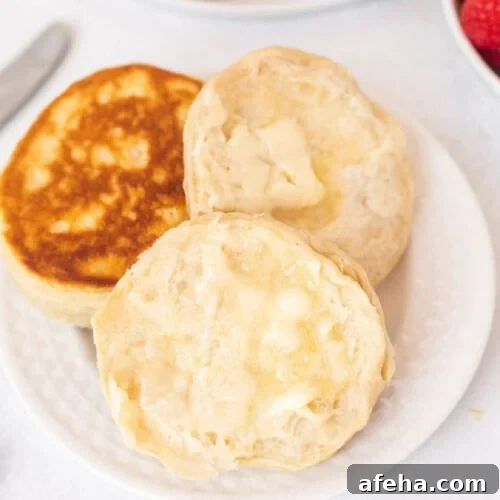 Canned Biscuits on a plate topped with melted butter.