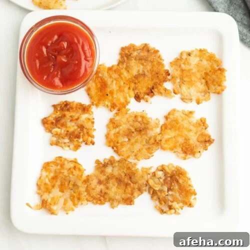 A plate with some smashed potato and ketchup.