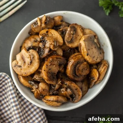 A white bowl filled with sautéed mushrooms.