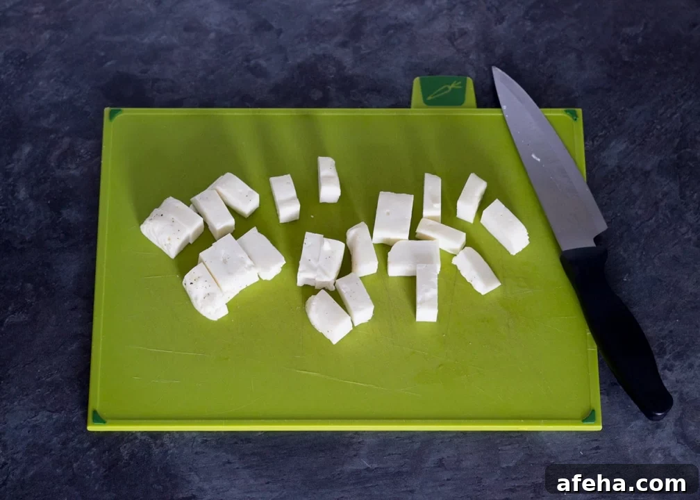Chopped halloumi on a chopping board.