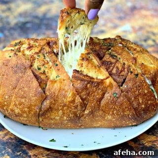 person pulling a piece of air fryer pull apart garlic cheese bread