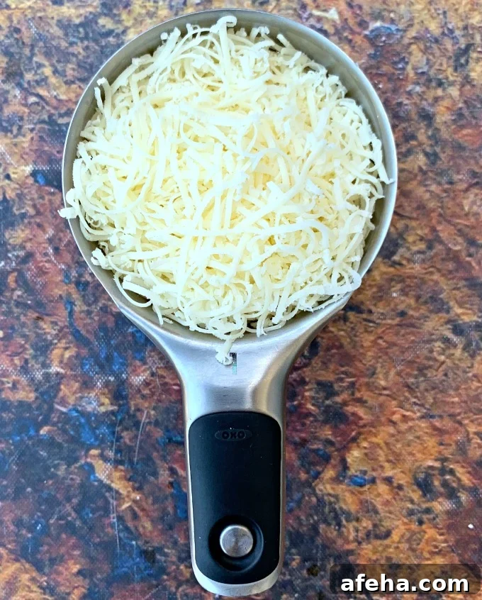 shredded mozzarella cheese in a measuring cup