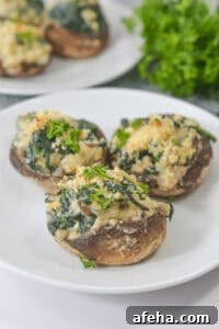 Three boursin cheese stuffed mushrooms filled with spinach and topped with breadcrumbs.