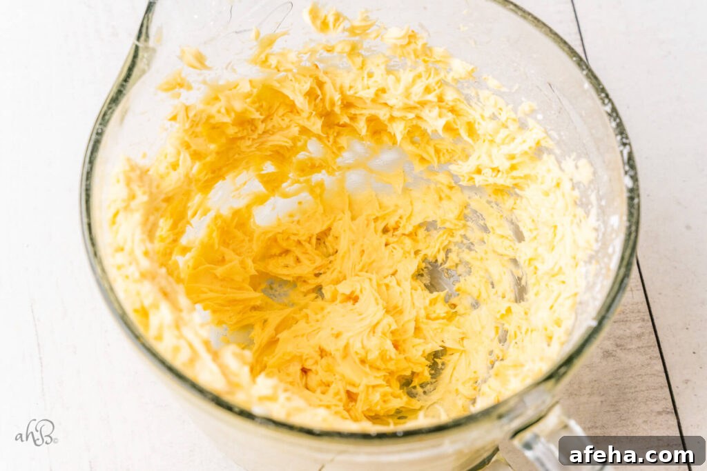 The butter and sugar have been blended together in a glass measuring bowl.