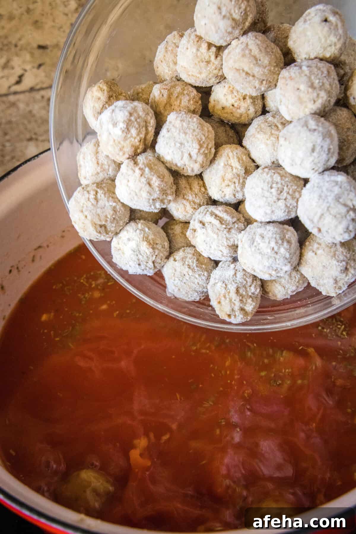 Hearty Italian Meatball Soup Recipe with Tender Meatballs 4 adding frozen meatballs to pot of soup