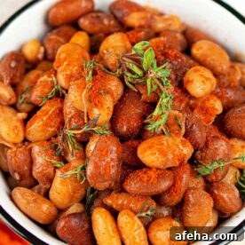 A bowl of seasoned roasted tepary beans garnished with fresh herbs.