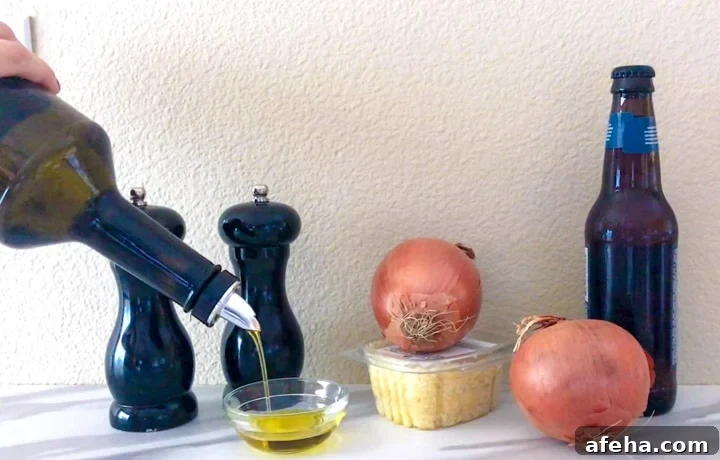 Ingredients on table, including olive oil, salt, pepper, onions, beer and garlic.