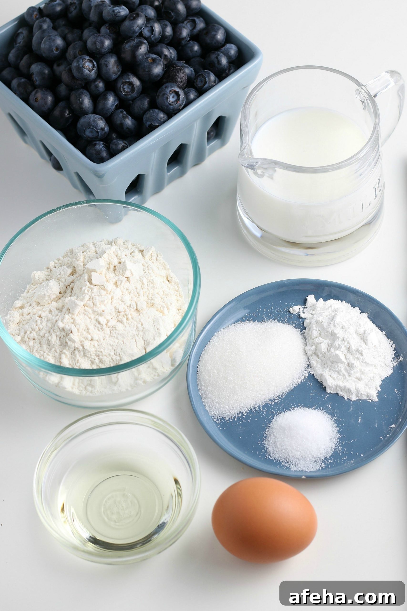 ingredients for homemade blueberry pancakes on a white countertop