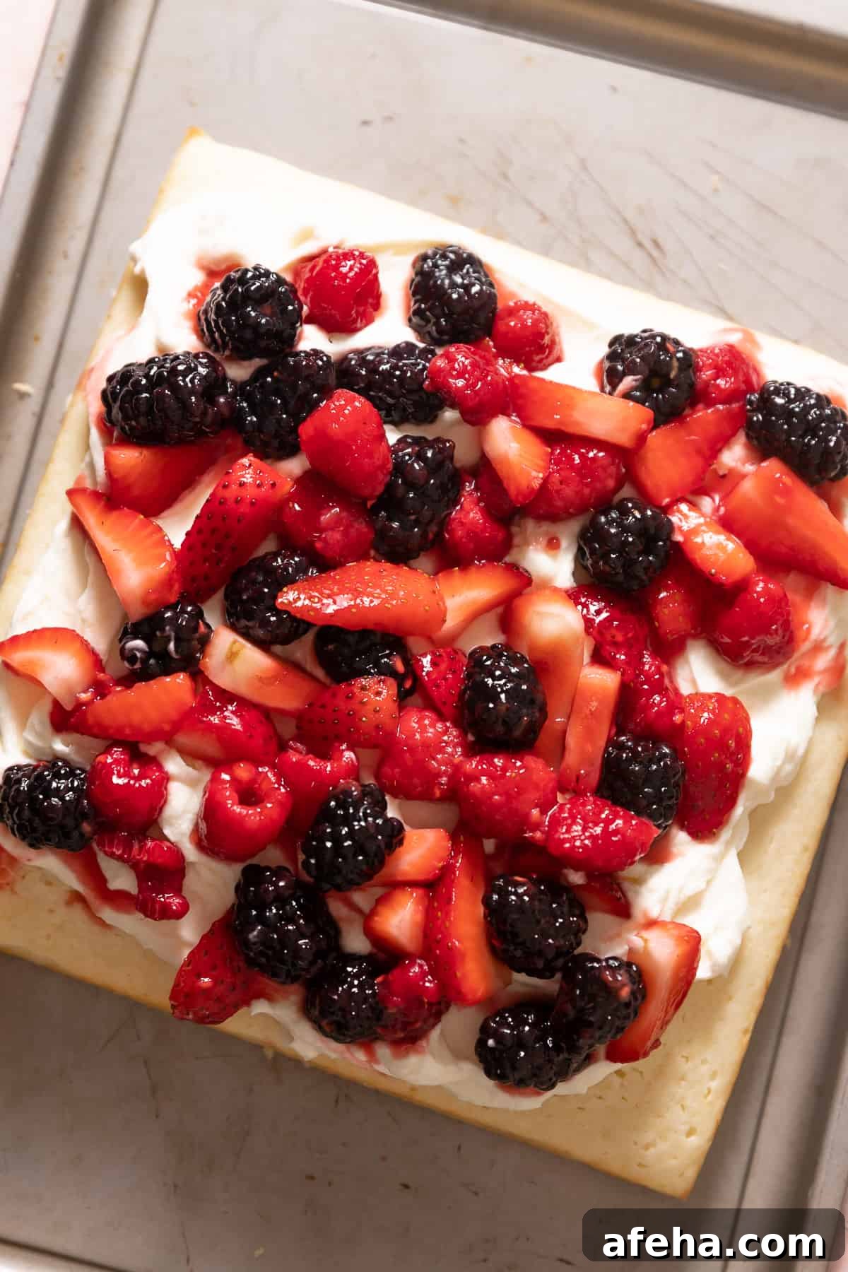 lemon cake with mascarpone frosting and fresh berries on top.