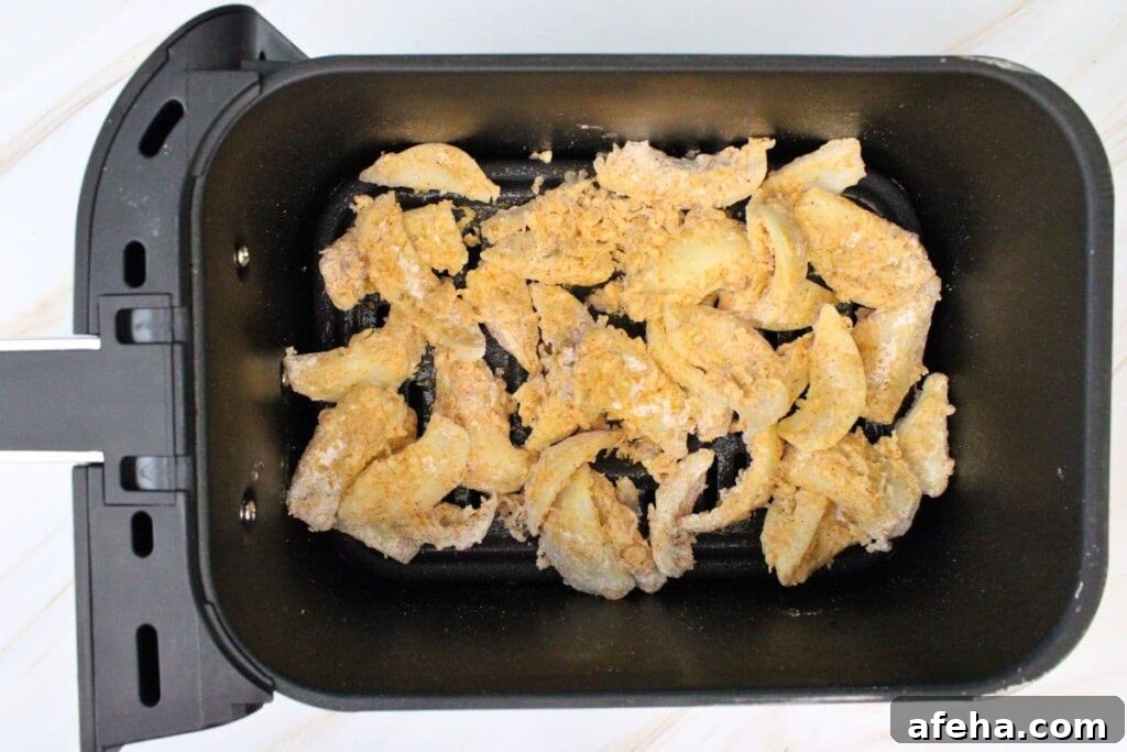 add onions to air fryer basket and spray with nonstick oil