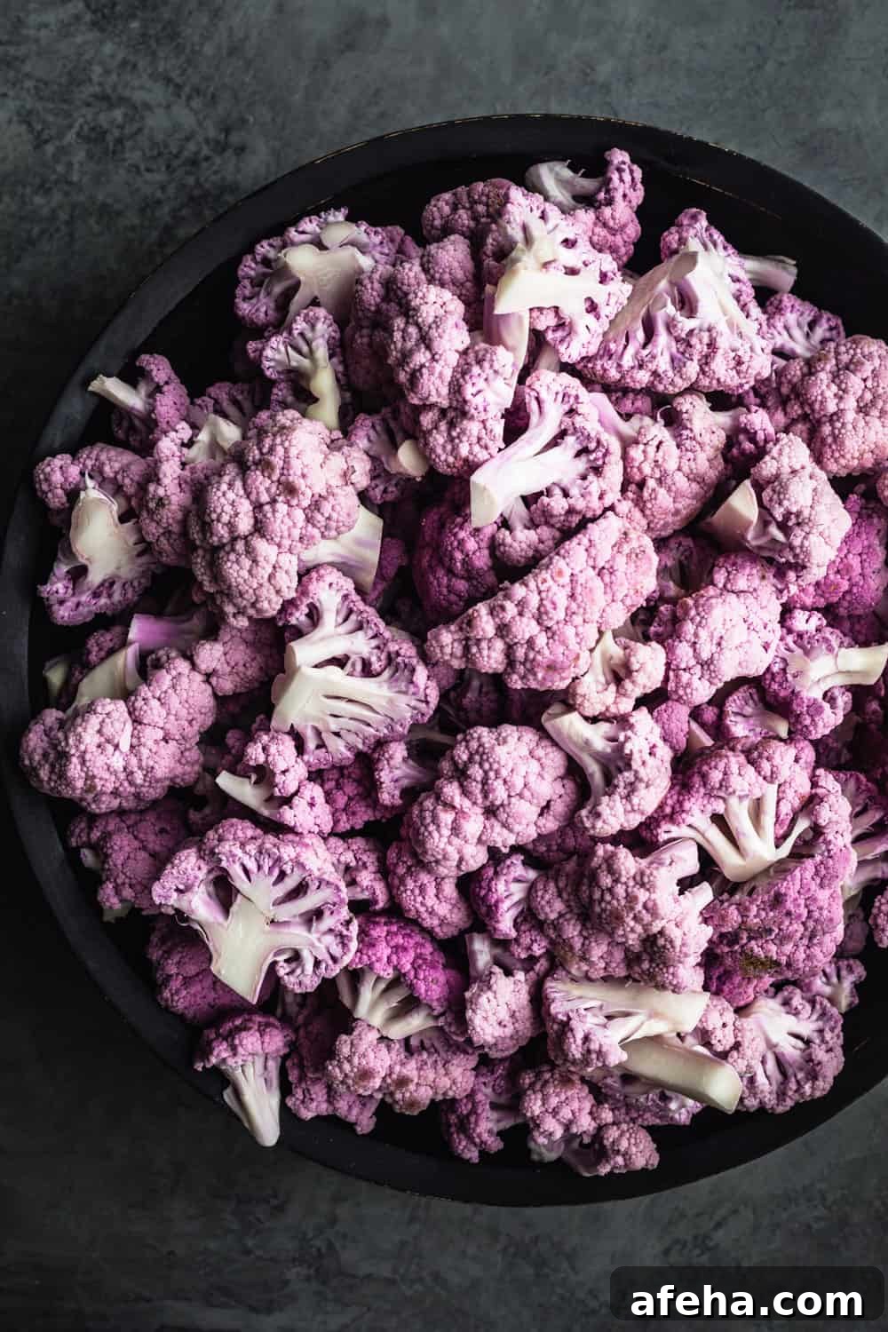 Purple Cauliflower Varieties: Flavor, Nutrition & Cooking Tips 7 purple cauliflower florets in black bowl