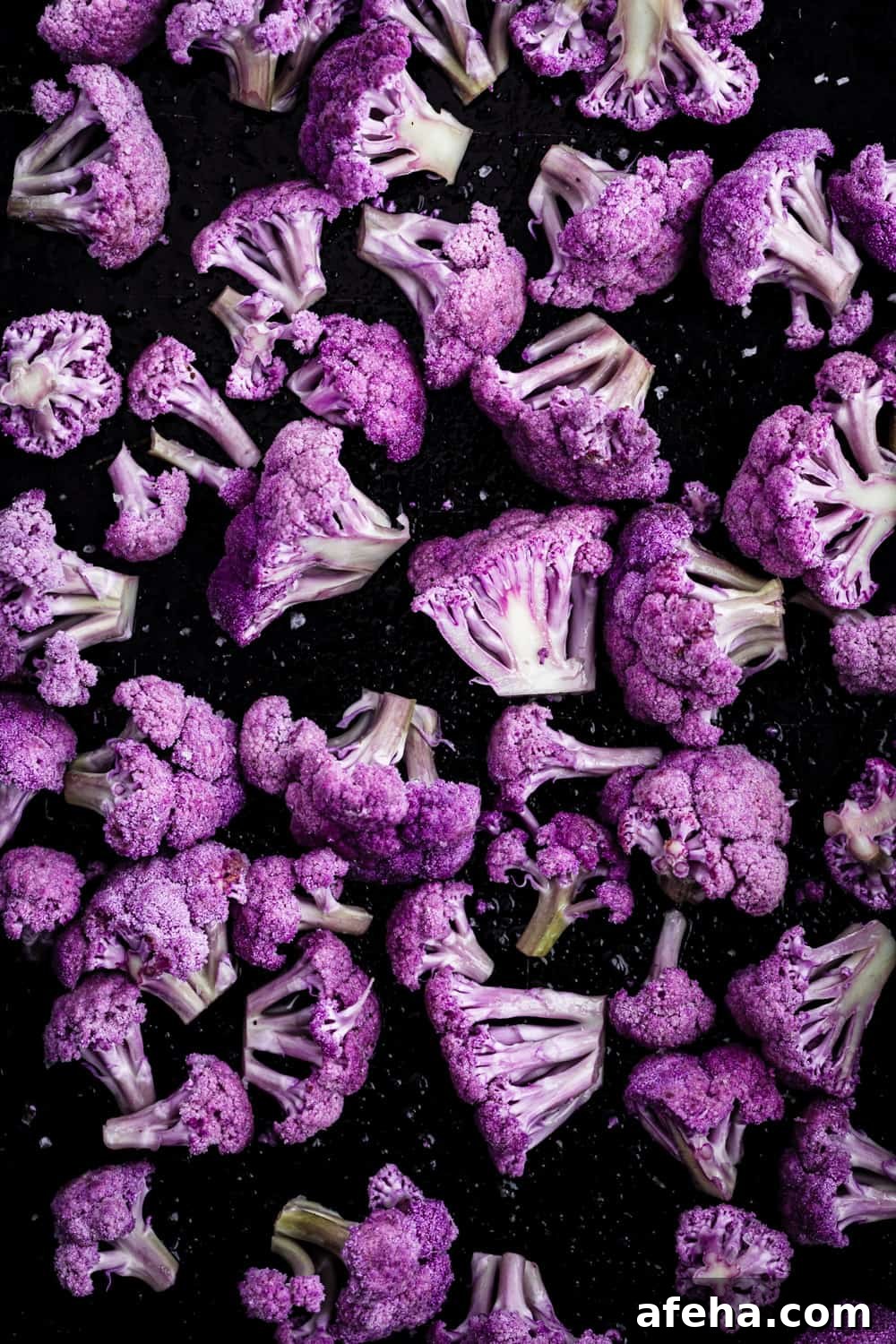 Purple Cauliflower Varieties: Flavor, Nutrition & Cooking Tips 8 purple cauliflower florets on a baking sheet