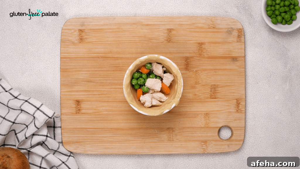 Gluten-Free Chicken Pot Pie Recipe: Flaky Crust & Creamy Filling 11 Add your filling to the chicken pot pies. Next, you'll add the gravy.