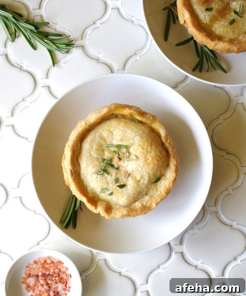 Gluten-Free Chicken Pot Pie Recipe: Flaky Crust & Creamy Filling 3 A Gluten-Free Chicken Pot Pie topped with salt and rosemary on a white plate