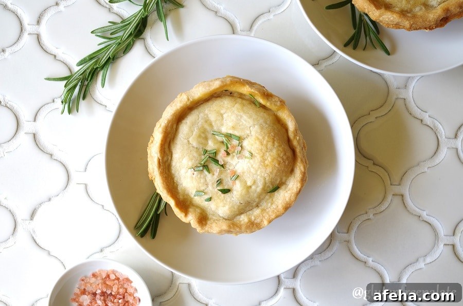 Gluten-Free Chicken Pot Pie Recipe: Flaky Crust & Creamy Filling 5 a close up of A Gluten-Free Chicken Pot Pie topped with salt and rosemary on a white plate
